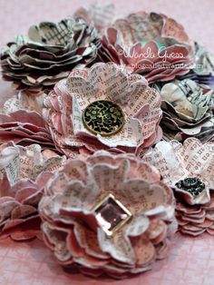 some paper flowers are sitting on a pink table cloth with words written all over them