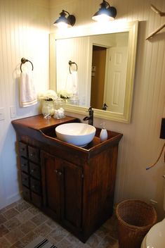 a bathroom with a sink, mirror and towel rack