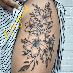 a woman's thigh with flowers and leaves tattoo on her side, showing the lower half