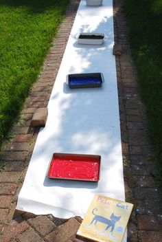 a long white table with red and blue lights on it's sides in the grass