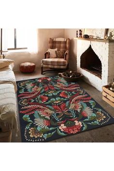 a living room with a fireplace, chair and rug on the floor in front of it