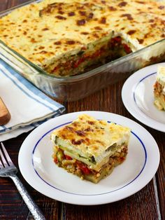 a casserole dish with meat and vegetables on two plates next to a fork