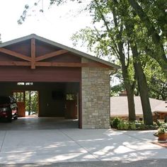 a car is parked in front of a garage with an attached carport on the driveway