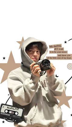 a man in a white hoodie taking a photo with a camera and some stars around him