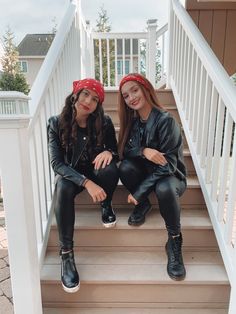 two young women sitting on the steps of a house wearing black leather jackets and bandanas