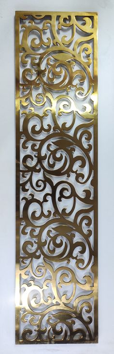 an intricate metal panel on the wall in a room with white walls and flooring