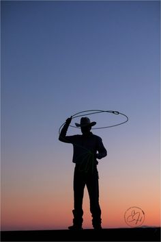 a man standing on top of a hill holding a hula hoop in his hand