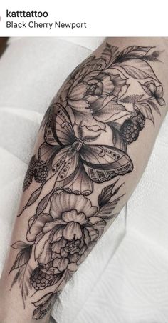 a woman's arm with flowers and butterflies on it, in black and white