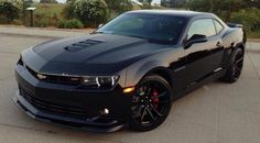 a black chevrolet camaro parked in a parking lot