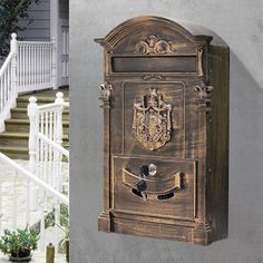 an old fashioned mailbox on the side of a house next to a white staircase