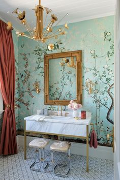 the bathroom is decorated in shades of blue and gold with floral wallpaper on the walls