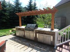 an outdoor kitchen with grill and seating area