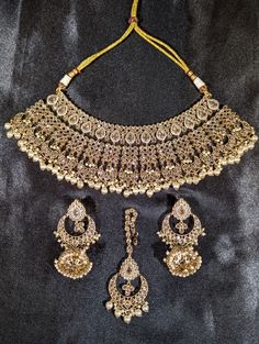 a necklace and earring set is shown on a black background with gold trimmings