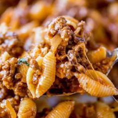 a spoon full of pasta with meat and cheese on it's side, ready to be eaten