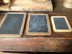 three chalkboards sitting on top of a wooden table