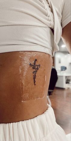 a woman with a cross tattoo on her lower back and the bottom part of her leg