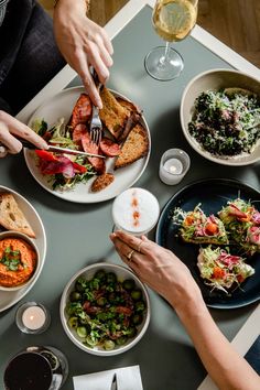 people are sitting at a table with plates of food