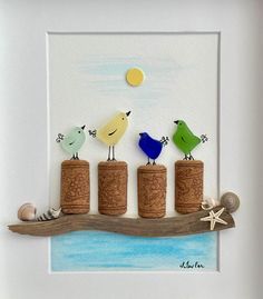 three birds sitting on top of corks in front of a white frame with starfish