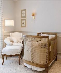 a baby's crib in the corner of a room with a white chair