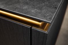 a close up of a black cabinet with gold handles