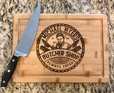 a wooden cutting board with a butcher shop logo on it and a knife next to it