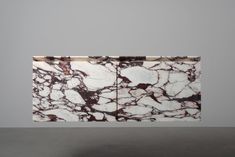 an abstract marbled surface is shown against a gray wall with two white and brown squares