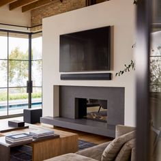 a living room with couches and a flat screen tv mounted on the wall above a fireplace