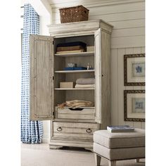 an armoire with drawers and shelves in a room