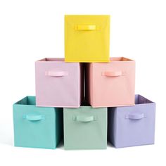 four different colored storage boxes stacked on top of each other with one yellow bow in the middle