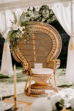 a wicker chair sitting on top of a grass covered field