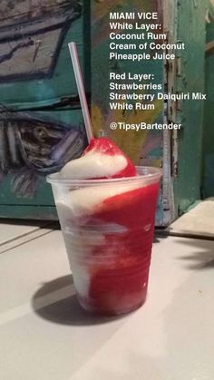 a red layer drink with whipped cream and a cherry on top in a plastic cup