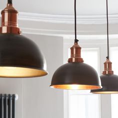 three pendant lights hanging from the ceiling in a room