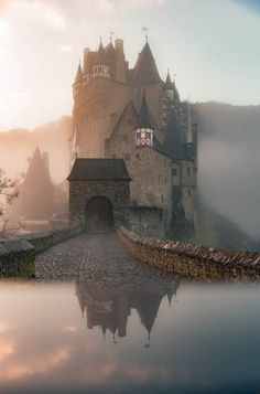 an old castle is shown in the fog