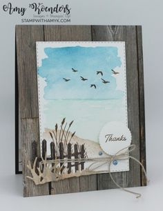 a handmade card with watercolors and birds flying in the sky over a beach