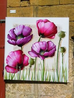 a painting of purple flowers on a brick wall