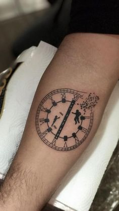 a man's arm with a clock tattoo on it