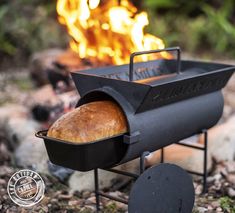 a bread roaster sitting on top of a metal stand in front of a fire