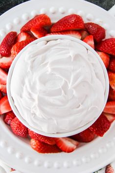 a white plate topped with strawberries and whipped cream