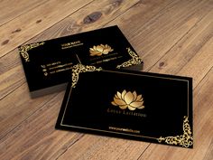 two black and gold business cards sitting on top of a wooden floor