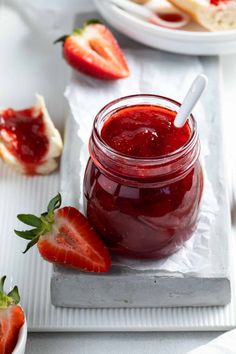 strawberry jam in a jar with strawberries on the side