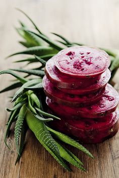 a pile of beets sitting on top of a wooden cutting board