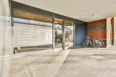 there is a bike parked in front of the glass doored entrance to this building