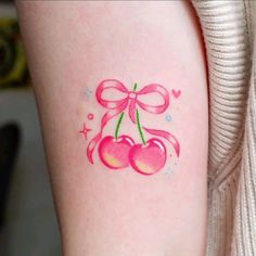 two cherries with pink bows on the arm