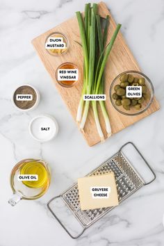 green onions, olives and other ingredients on a cutting board