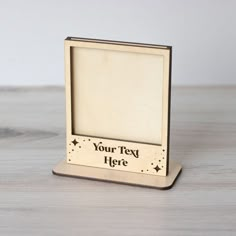 a wooden photo frame on a table with a white wall behind it and the words your text here