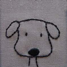 a dog's face is drawn on a piece of fabric with black thread in it