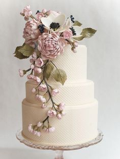 a wedding cake decorated with flowers and leaves