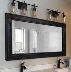 a bathroom sink with a mirror and lights above it