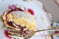 a piece of cake with powdered sugar on top and a fork in the foreground