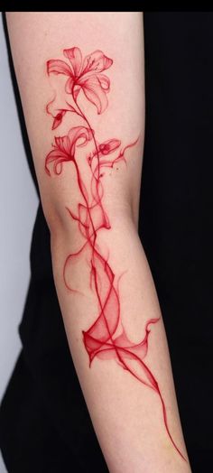 a woman's arm with red ink on it and a flower in the middle